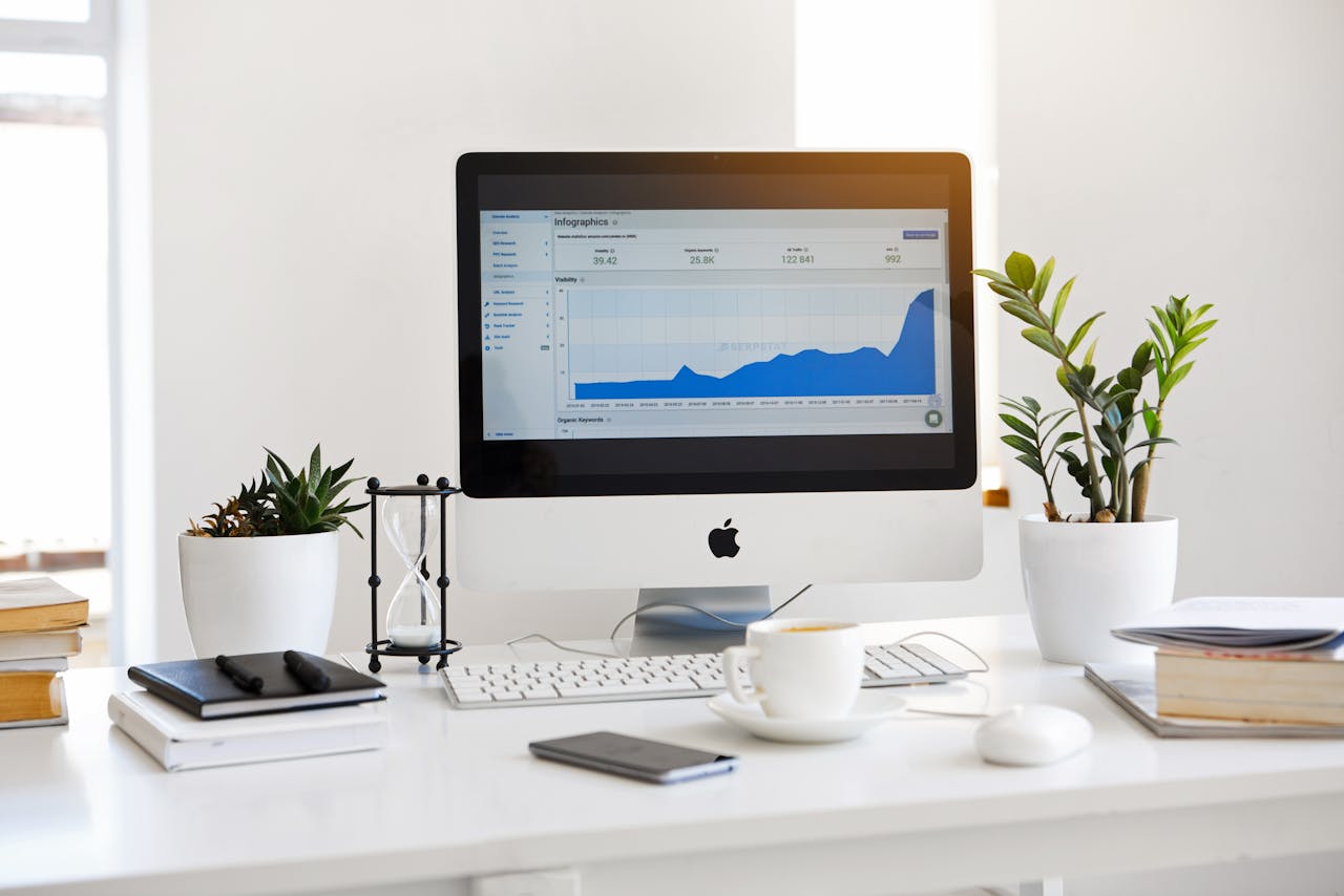 desk with a computer, plant, cup of coffee