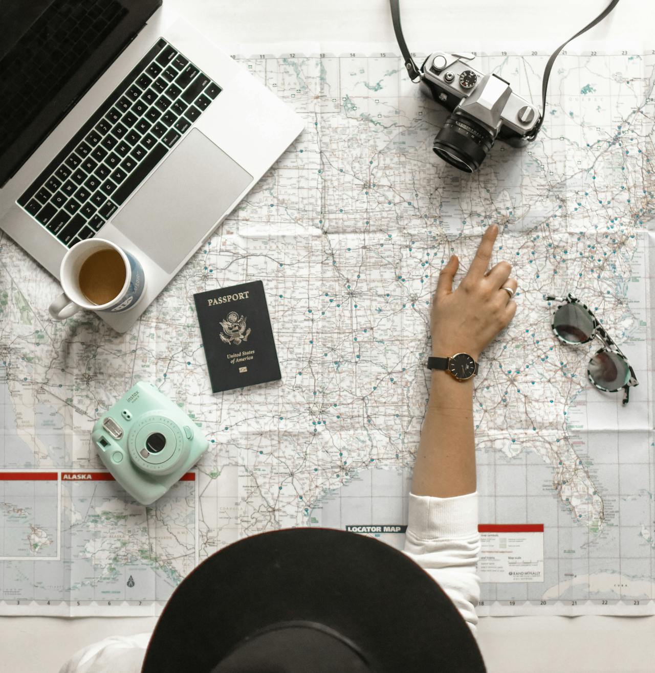 desktop with a laptop, camera, passport