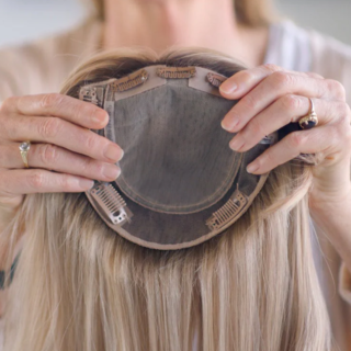 Woman holding hair topper piece.