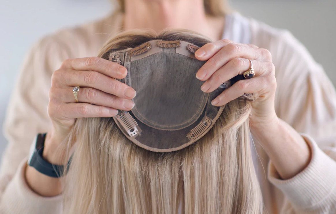 Woman holding hair topper piece.